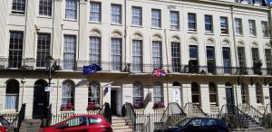 a large white building with cars parked in front of it at Andorra Guest Accommodation in Brighton & Hove