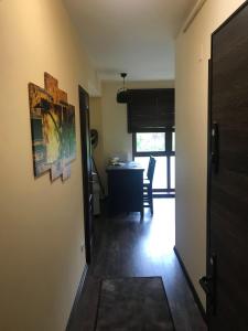 een hal met een kamer met een tafel en een deur bij Xili's green apartment in Braşov