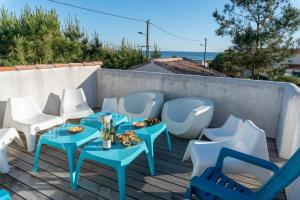 a patio with blue tables and white chairs at Sea-Snow Guest Houses in Talmont