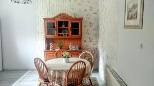 a dining room with a table and chairs and a cabinet at Apartament 42C in Ciechocinek