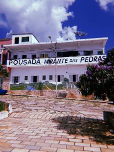 um edifício branco com um sinal na lateral em Pousada Mirante das Pedras em São Tomé das Letras