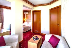 a hotel room with a couch and a bed at Hotel Cezar Banja Luka in Banja Luka
