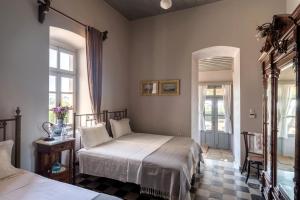 a bedroom with two beds and a mirror at DellaGracia Mansion in Poseidonia Syros in Posidhonía +38 photos