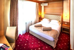 a hotel room with a bed and a dresser at Hotel Cezar Banja Luka in Banja Luka