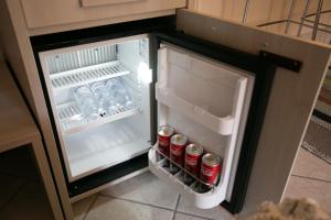 an open refrigerator with cans of soda in it at B&B Trepo in Tropea