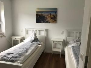RottorfにあるFerienwohnung Forstwegのベッドルーム1室(白いベッド2台、テーブル2台付)