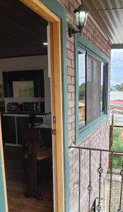 eine Tür zu einer Terrasse mit einem Tisch und einem Fenster in der Unterkunft The Gardens in San José