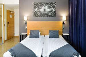 a bedroom with a bed with two blue pillows at Hotel Allén - Sure Hotel by Best Western Allen in Gothenburg