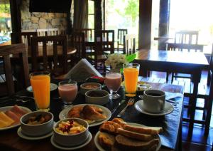 una mesa con comida para el desayuno y bebidas en ella en Hosteria Casagrande en Tandil