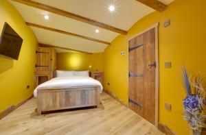 a bedroom with a bed and a wooden door at Oastbrook Vineyard in Bodiam