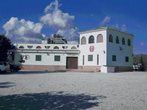 un grand bâtiment blanc avec un garage dans un parking dans l'établissement Finca Buenavista, à Xilxes