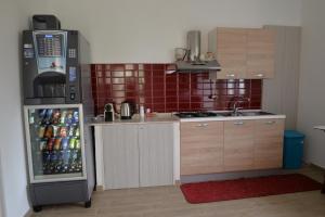 uma pequena cozinha com frigorífico e bebidas em B&B Lara Santola em Corato