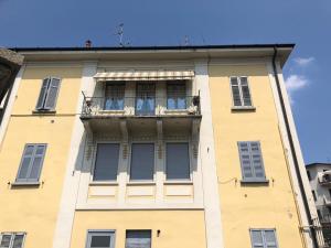 - un bâtiment jaune avec un balcon sur le côté dans l'établissement Sparkling Art Como, à Côme