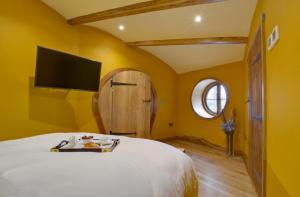 a bedroom with a bed with a tv on the wall at Oastbrook Vineyard in Bodiam