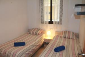 2 camas individuais num quarto com uma janela em Piso Regina em Lloret de Mar
