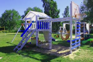 a playground with a ladder and a slide at Villa Happy Rose in Dąbki