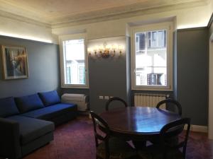 ein Wohnzimmer mit einem Tisch und einem blauen Sofa in der Unterkunft BORGO SAN FREDIANO SUITES in Florenz