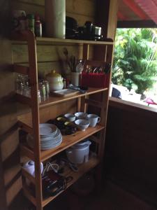 una cocina con estanterías de madera con platos y una ventana en Middle Country 97-1 "la recette du bonheur" en Deshaies