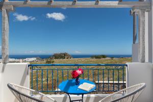 a blue table and chairs on a balcony with the ocean at 'Lindian Myth' Sea View Studios in Lindos