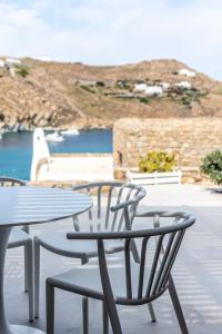 d'une table et de chaises avec vue sur l'océan. dans l'établissement Etesians Suites & Villas, à Plage de Super Paradise