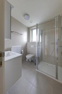 a bathroom with a shower and a sink and a toilet at Aan de duinbossen in De Haan