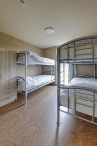 a room with three bunk beds in it at Aan de duinbossen in De Haan