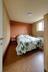 a bedroom with a bed with a green comforter at Aan de duinbossen in De Haan