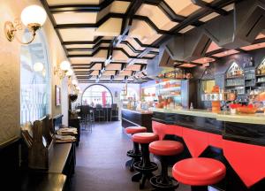 un bar con sgabelli rossi in un ristorante di Camping Olympia a Dobbiaco