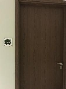 een houten deur in een kamer met een bord erop bij Ruang Bravia Bogor Icon Hotel in Bogor