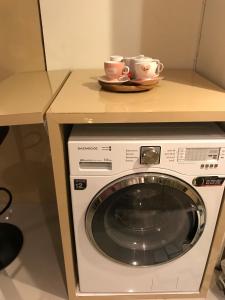 a washing machine with two cups on top of it at Ruang Bravia Bogor Icon Hotel in Bogor