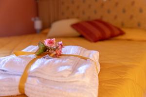 a white towel with a bouquet of flowers on a bed at Mansarda da Dani in Brolo