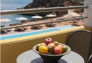 a bowl of fruit on a table with a view of the beach at Apolis Beachscape Hotel in Amoopi