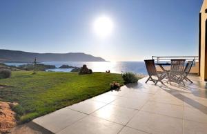a patio with two chairs and a view of the ocean at Apolis Beachscape Hotel in Amoopi