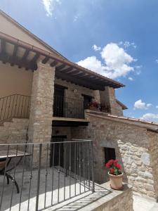 een stenen huis met een balkon en een patio bij Agriturismo I CASALI DI MORRO in Sellano