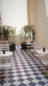 a room with tables and potted plants on a checkered floor at Pistoia INN - Downtown's Charming Rooms in Pistoia