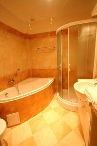 ein Badezimmer mit einer Badewanne, einem WC und einem Waschbecken in der Unterkunft Apart Hotel Susa in Prag