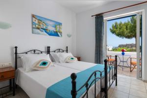a bedroom with a bed and a balcony at 'Lindian Myth' Sea View Studios in Lindos