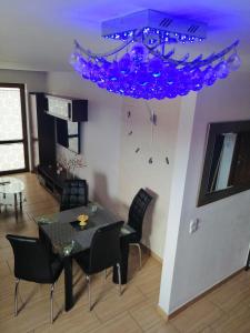 a dining room with a table and a purple chandelier at Apartament Piotr in Łeba