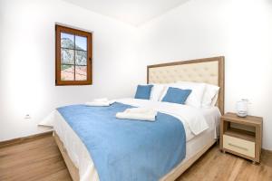 a bedroom with a large bed with two towels on it at Apartments Mezini 11 in Kotor +111 photos