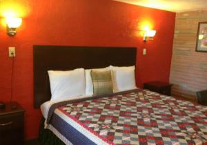 1 dormitorio con 1 cama grande y pared roja en Holly Motel Southampton, en Southampton