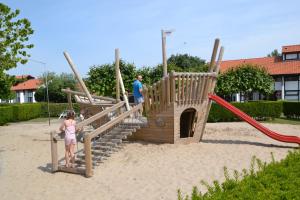 a man and a little girl playing in a playground at Vakantiewoning De Zandkorrel in Middelkerke