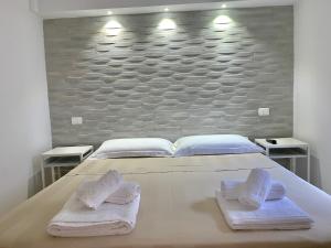 1 dormitorio con 1 cama grande y toallas. en Salentoguests villetta sulla spiaggia, en Porto Cesareo
