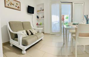 a living room with a couch and a dining room at Salentoguests villetta sulla spiaggia in Porto Cesareo