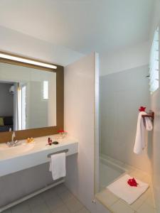 W łazience znajduje się umywalka, lustro i prysznic. w obiekcie STUDIO DJANGO w mieście Saint-François