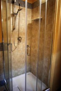 La salle de bains est pourvue d'une douche avec une porte en verre. dans l'établissement B&B Le Casette Di Lù, à Agrigente