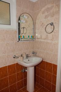 a bathroom with a sink and a mirror at Maspali Apartments in Lixouri +58 photos