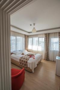 a bedroom with a large bed and a red chair at Villa Vongole in Çeşme