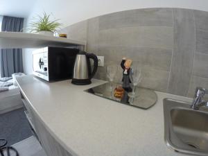 a kitchen counter with a microwave and two wine glasses at sweet home in Ivano-Frankivsʼk +4 photos