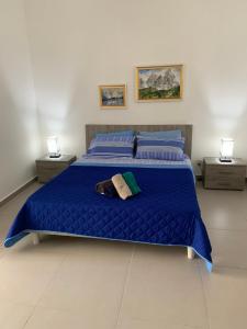 a bedroom with a blue bed with two night stands at Island Break Residence in Marsalforn