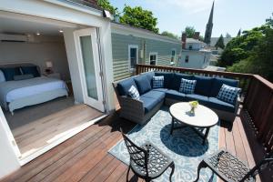 a deck with a couch and a table and chairs at Serenity Inn Newport in Newport